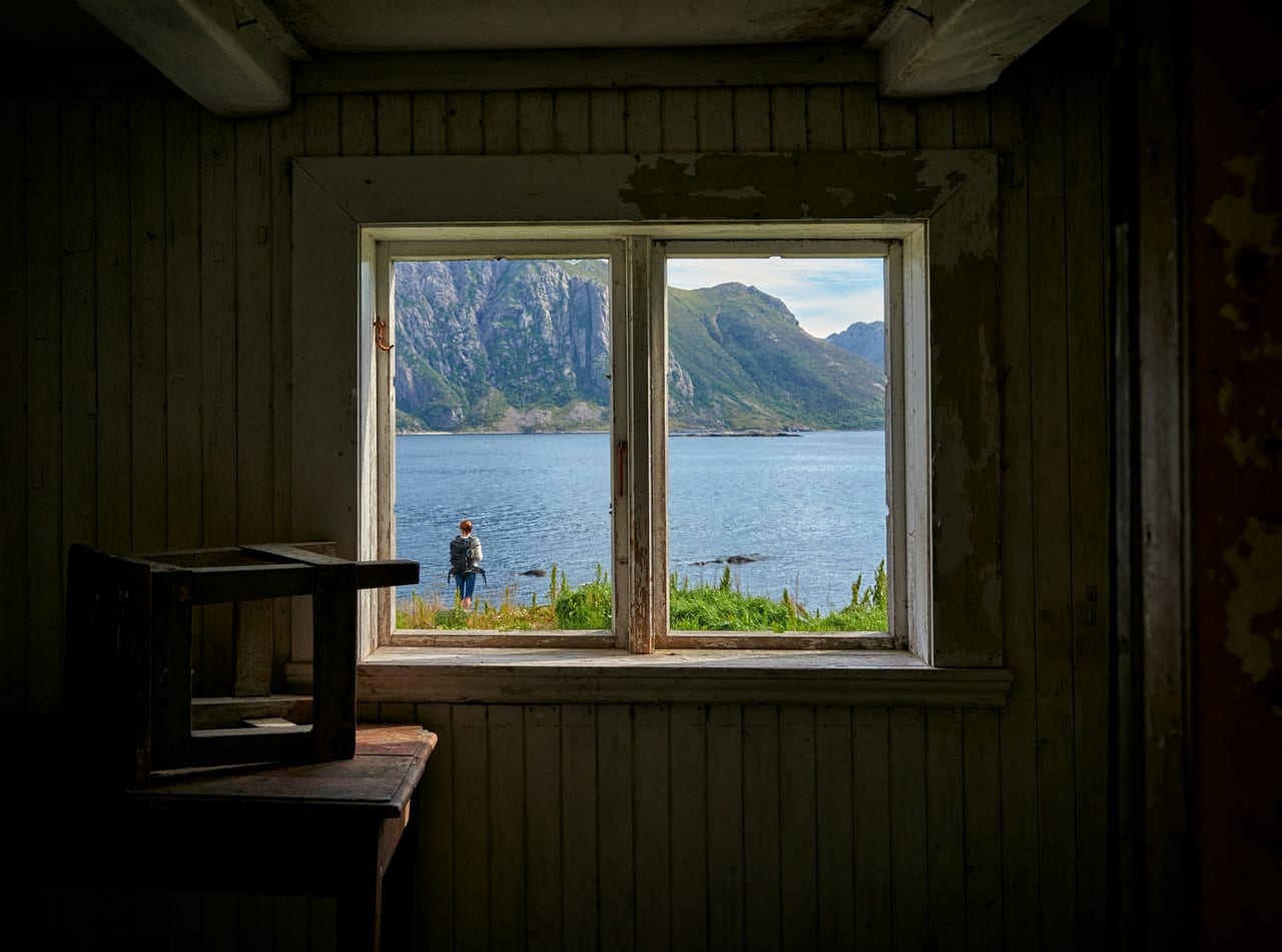 Una habitación de madera con una ventana al fiordo. Solo se mueve el agua de fuera.